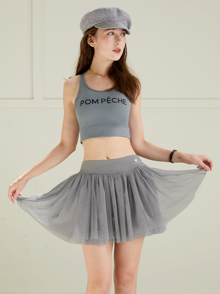 Grey puff tulle tennis skirt paired with matching sports top, highlighting lightweight mesh layers and high-waisted tennis skirt design.