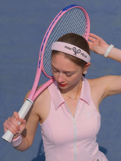 Woman holding a pink tennis racket on a blue court