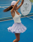 Woman playing tennis on a court with a visible logo in the background