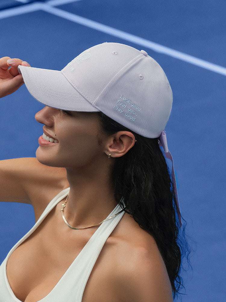 Purple tennis baseball cap with embroidered Pom Pêche logo and detachable ribbon.
