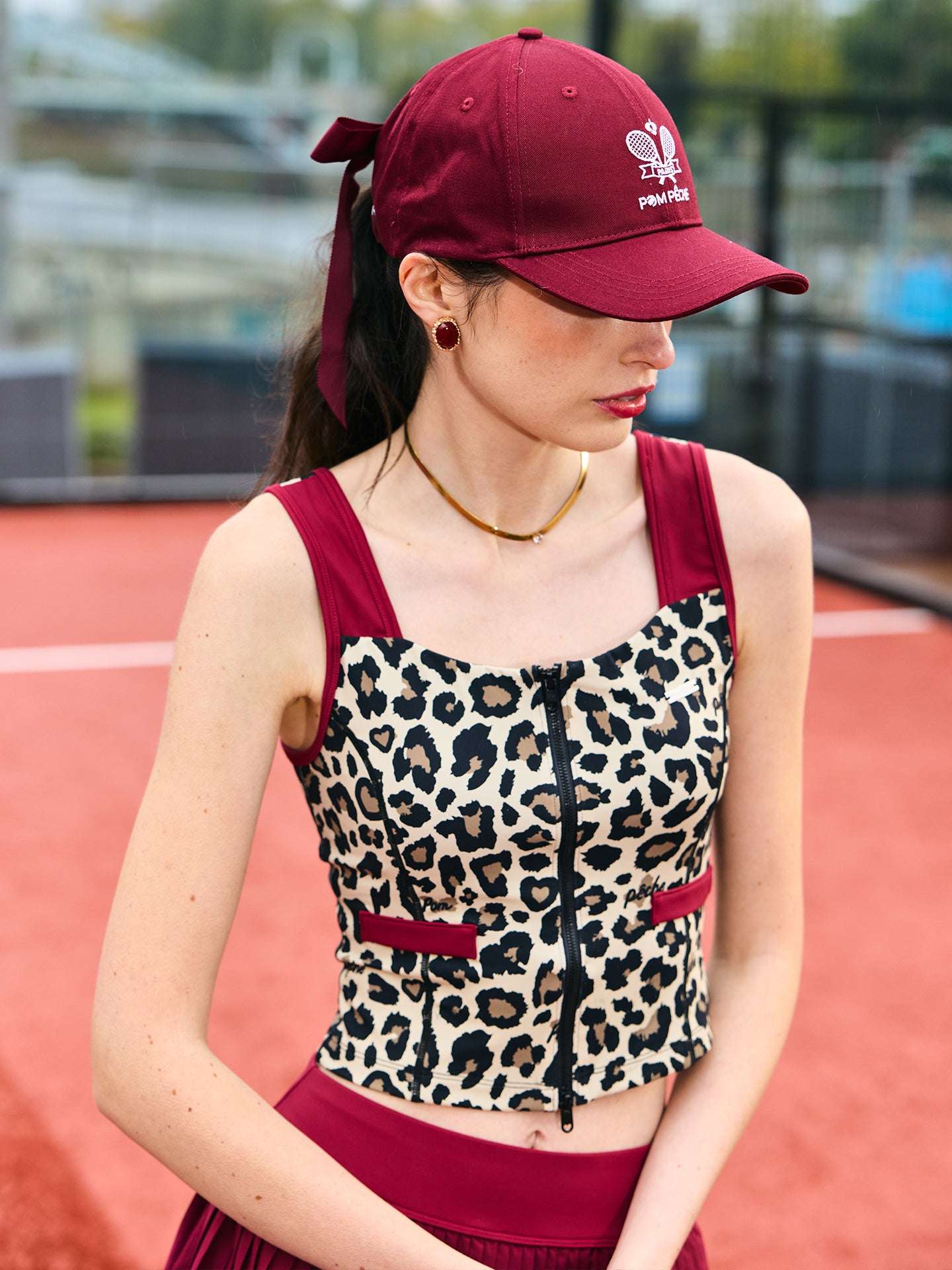 Leopard print sports tank with contrast straps and a zip front. Fitted, chic, and perfect for elevating on-court look.