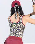 Leopard print sports tank with contrast straps and a zip front. Fitted, chic, and perfect for elevating on-court look.