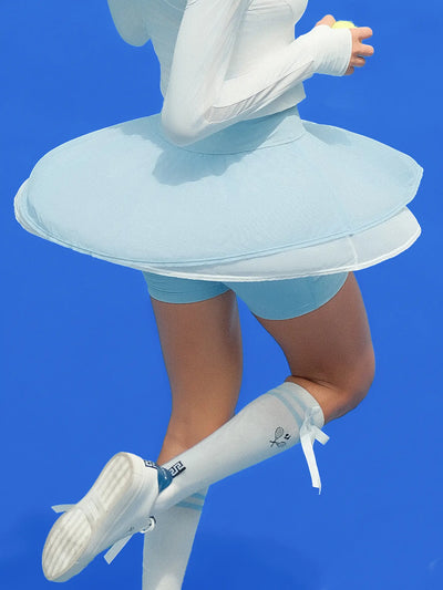 Light blue layered tennis skirt with chiffon layers and built-in shorts, offering a soft, breathable fit.