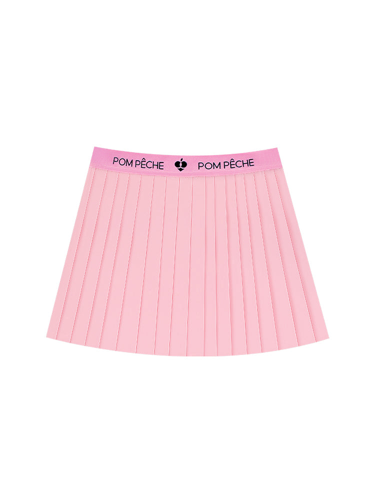 A sporty outfit features a light pink pleated tennis skirt designed for women’s tennis, pickleball and activewear looks.