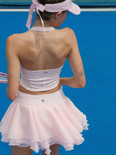 Person wearing a white tennis outfit with a visor against a blue background