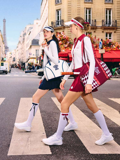 White polo top with navy blue collar and printed logo, worn on the city street for a stylish, casual look.