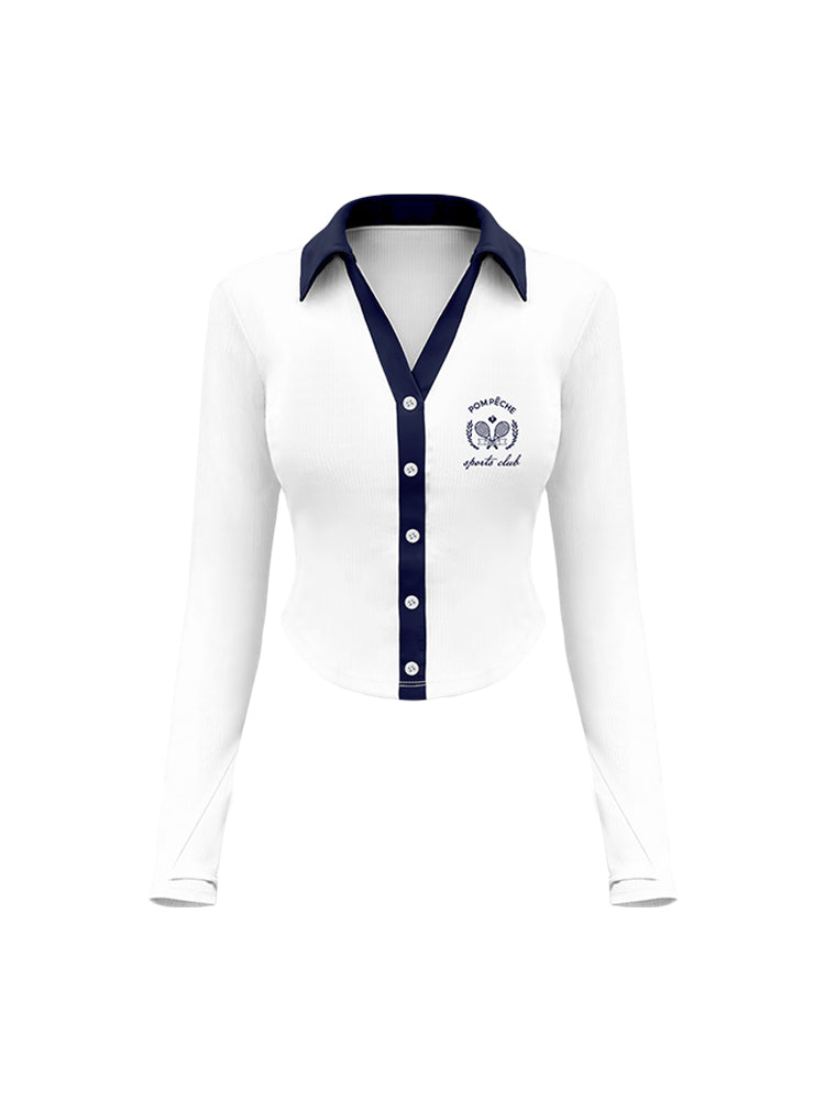 White polo top with navy blue collar and printed logo, worn on the city street for a stylish, casual look.