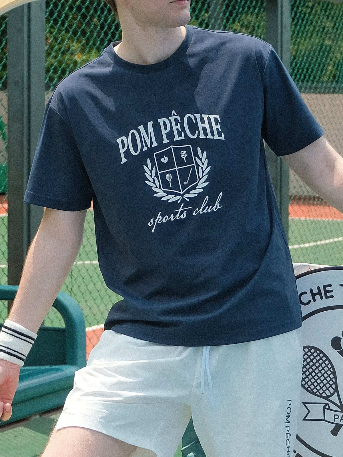Navy blue graphic tee with a white bold Pom Pêche logo, offering a relaxed fit for ultimate comfort and style.