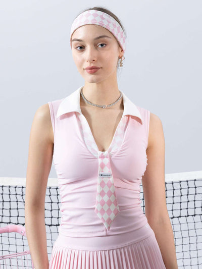 Soft pink slim-fit tennis top with a playful diamond-pattern tie detail, styled for a chic on-court look.