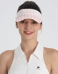 Pink checkered tennis visor with Pom Pêche logo and adjustable strap.