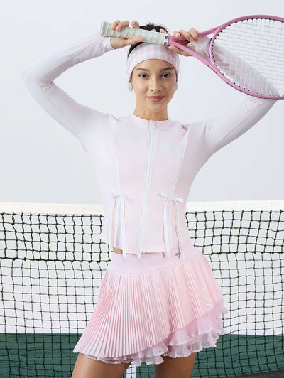 Pink sun-protective tennis jacket with a sculpted fit, adjustable waist ties, and dual ball pockets.