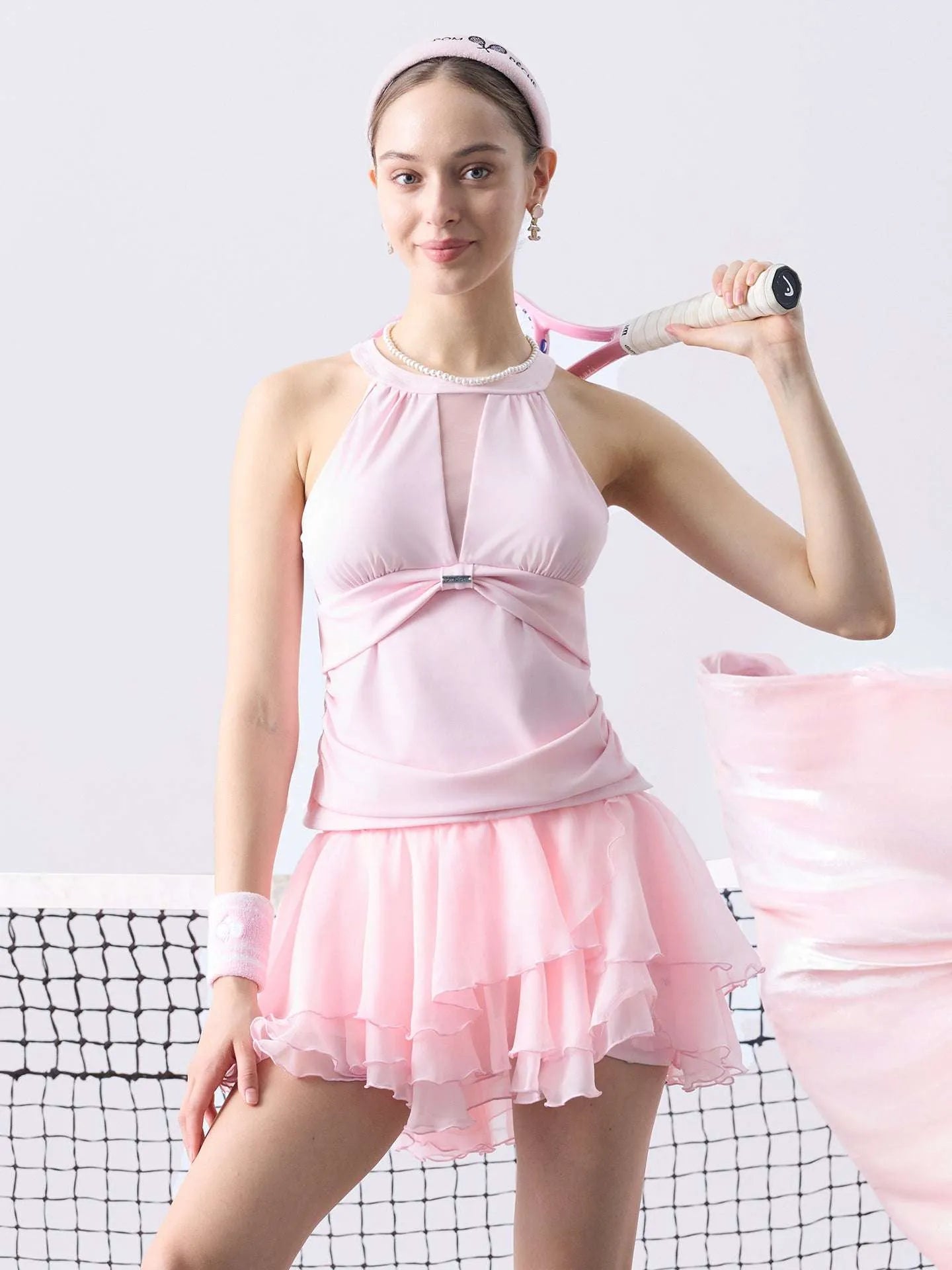 Women’s mesh halter tank and tiered tennis skirt set on tennis court, breathable sporty tennis outfit for performance and training