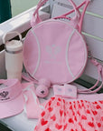 Pink sports bag, hat, towel, and other accessories on a white surface.