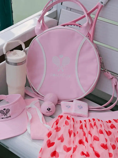 Pink sports bag, hat, towel, and other accessories on a white surface.