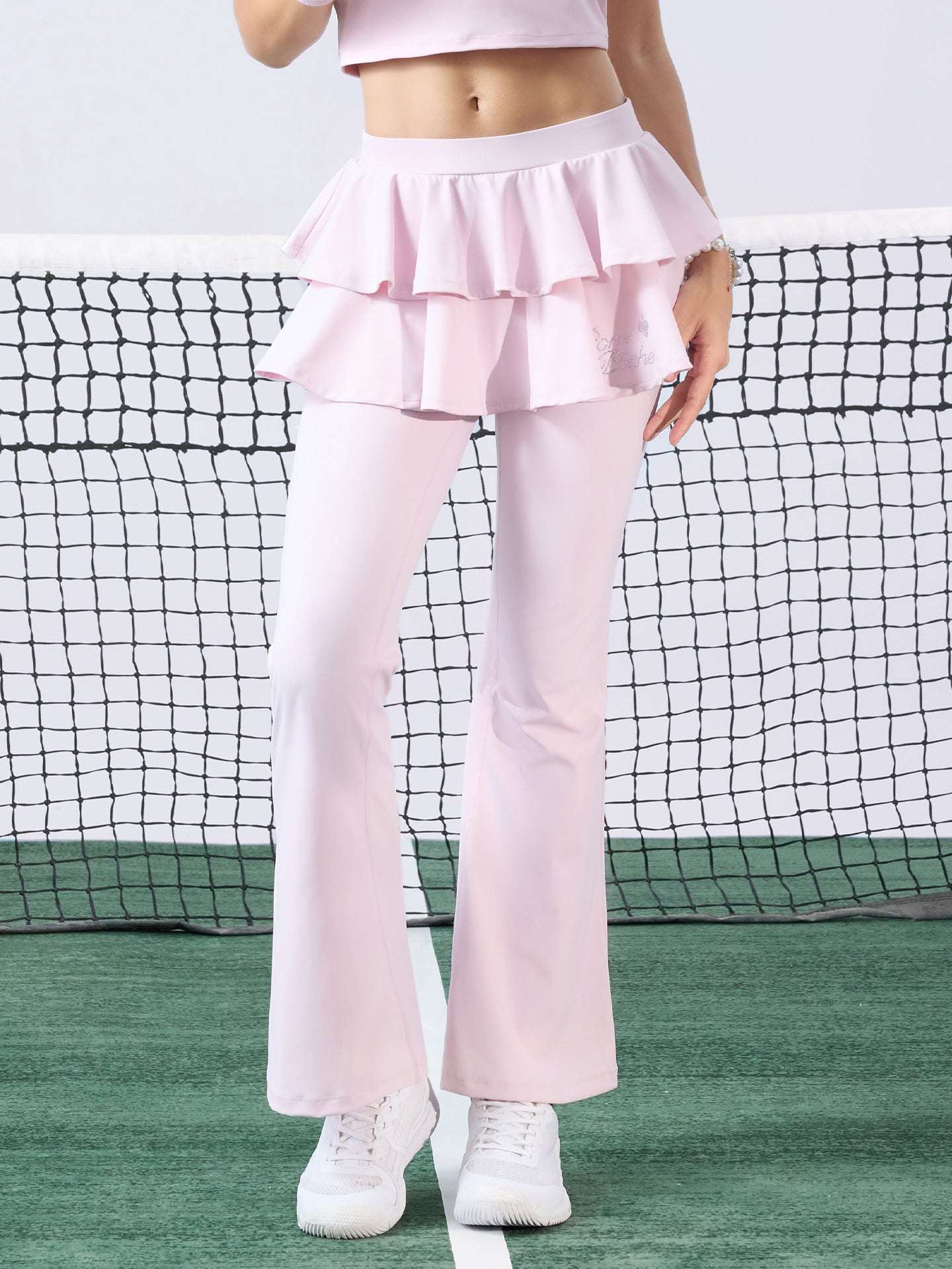 Pink flared tennis leggings with tiered-ruffle skirt, stretchy and breathable, easy movement from court to street.
