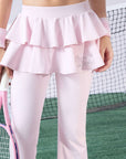 Pink flared tennis leggings with tiered-ruffle skirt, stretchy and breathable, easy movement from court to street.