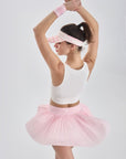 Back view of pink pleated skirt in motion, flaring gently as model raises arms to show flow and flexibility