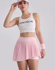 Front-facing pose showcasing high-waisted pleated skirt with built-in shorts for coverage and movement