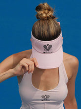 Pink tennis visor with embroidered Pom Pêche logo, white trim, and detachable ribbon at the back.