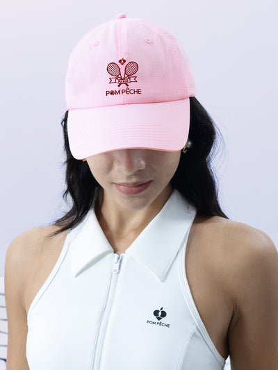 Pink tennis cap with embroidered logo and adjustable ribbon on the back strap.