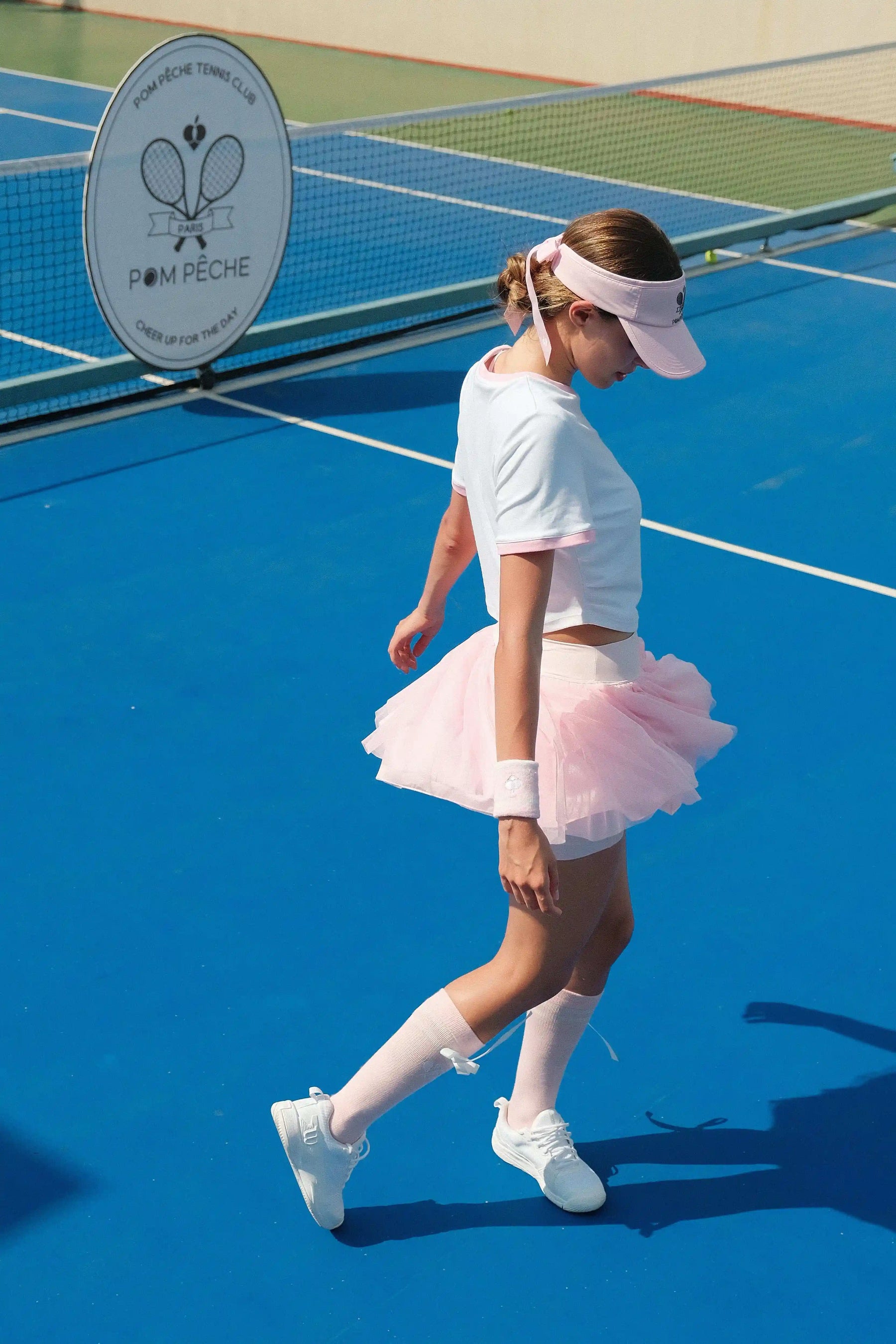 Pink tulle puff tennis skirt creating a light, floating silhouette on court, highlighting a high-waisted pink tennis skirt athletic look.