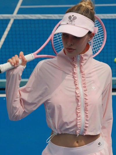 Person in pink tennis outfit holding a racket on a tennis court