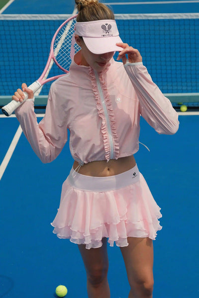 Woman in pink tennis outfit on a tennis court