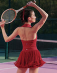 Woman in a red dress holding a tennis racket on a tennis court