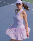 Woman in a purple tennis outfit on a tennis court