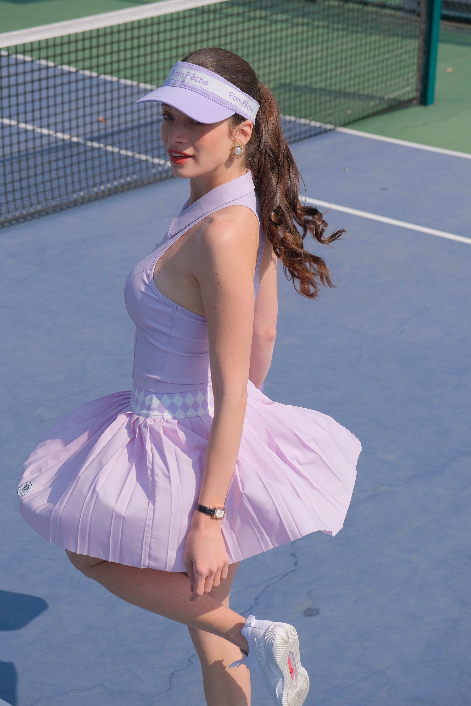 A pleated purple tennis skirt with an argyle waist is displayed as a breathable and stylish athletic skirt for on-court movement.