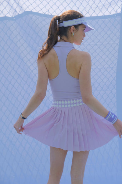 The purple pleated tennis skirt with an argyle waistband is showcased as a fashionable athletic skirt designed for tennis performance.