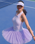 Model wearing a lavender tulle puff tennis skirt on court, highlighting airy layered mesh and a high-waisted athletic tennis skirt silhouette.