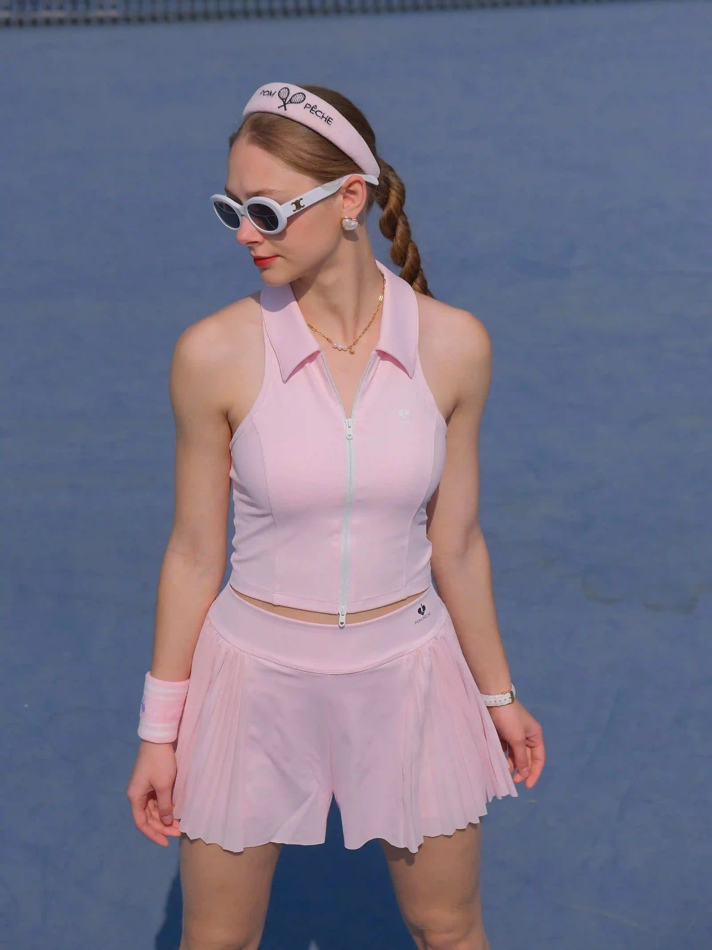 Woman in pink tennis outfit on a blue tennis court