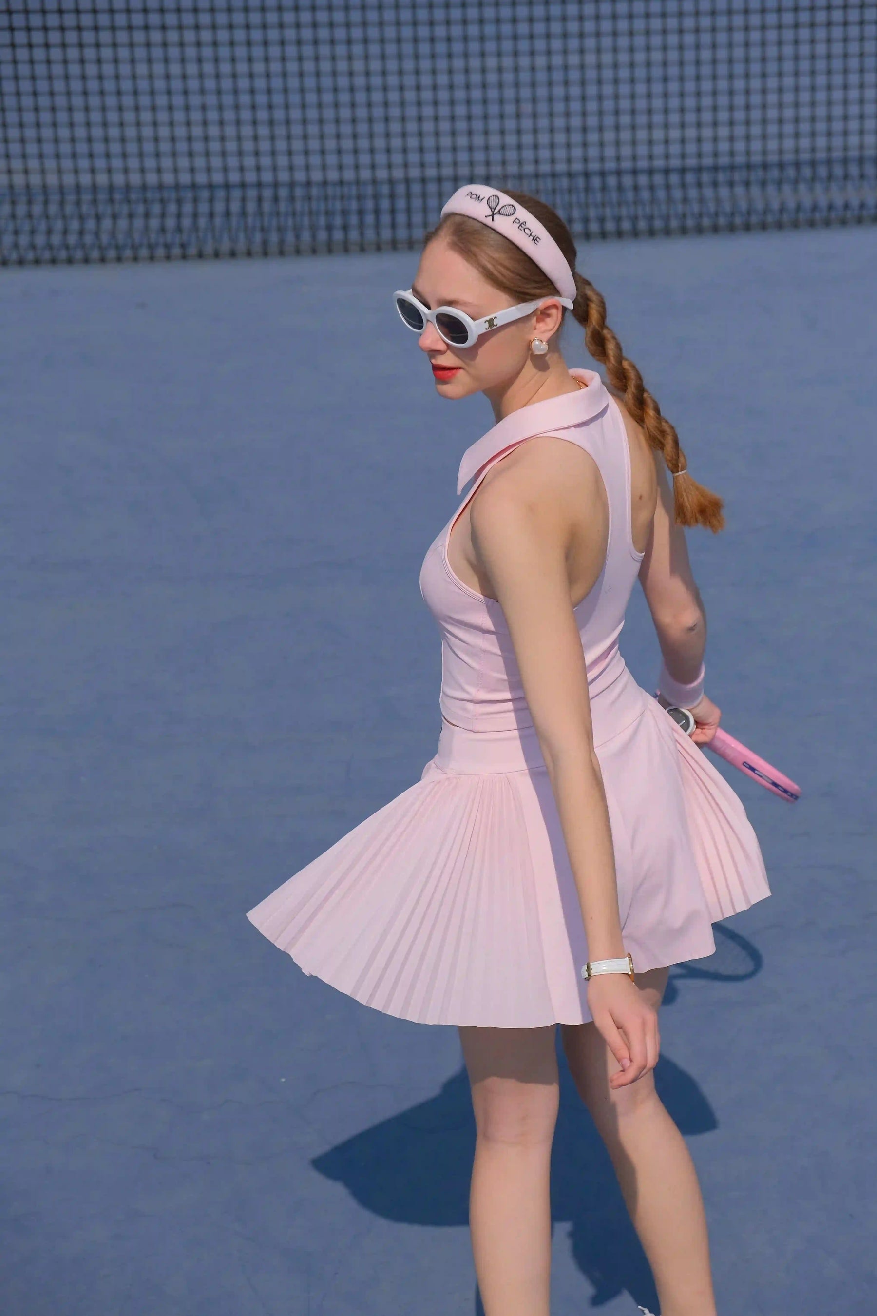 Woman in a pink tennis dress on a tennis court