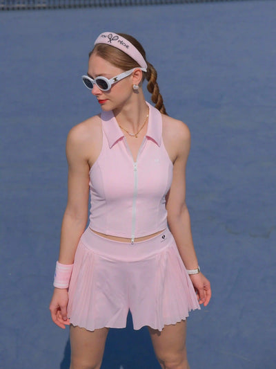 Woman in pink tennis outfit on a blue tennis court
