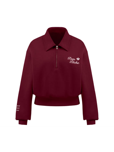 Red sweatshirt with quarter-zip design and embroidered logo on the front and back, offering a stylish and sporty look.