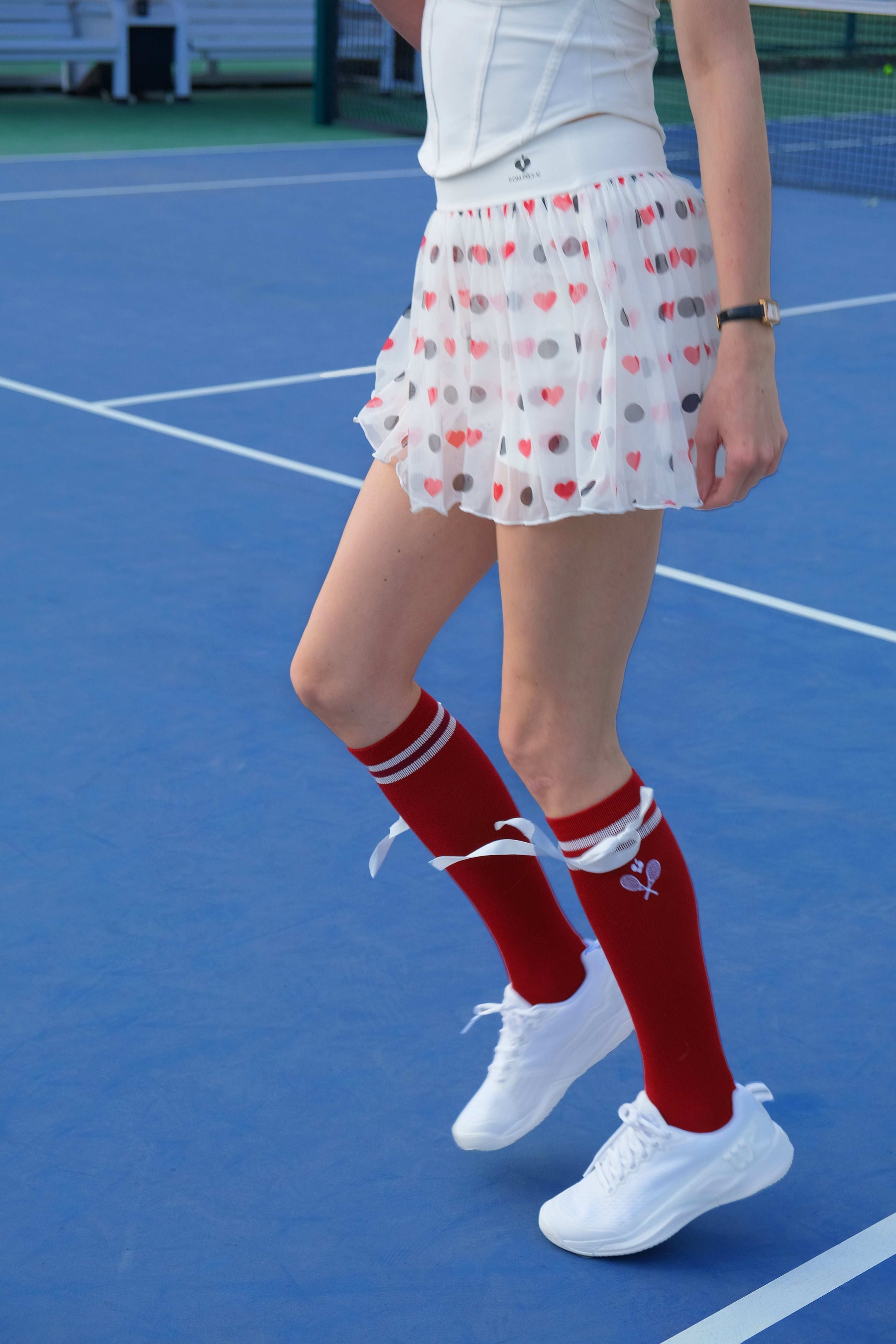 Deep Red knee-high tennis socks with white stripes, bow detail, and logo embroidery. 