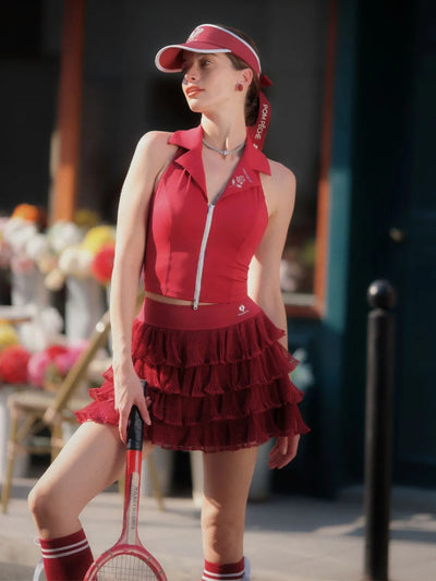 Woman in a red outfit with a tennis racket on a street.