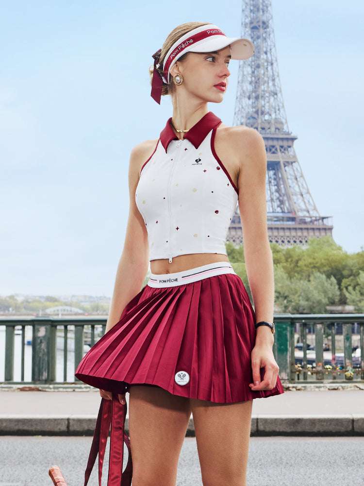 White zip-front tennis tank with red collar and star print, offering a chic, preppy look for court or city wear.