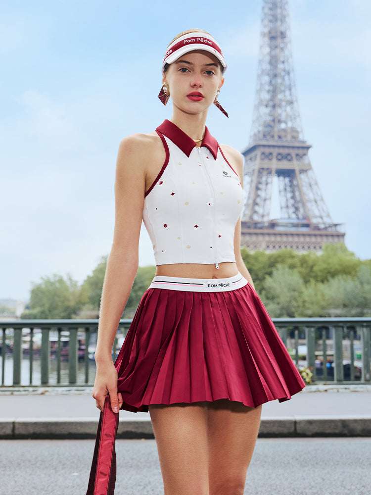 White zip-front tennis tank with red collar and star print, offering a chic, preppy look for court or city wear.