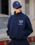Person wearing a navy blue hoodie and cap with 'Pompeche' branding.