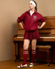 Woman in a red tracksuit standing in front of a piano