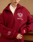 Person wearing a red fleece pullover with 'Pom Peche' branding.