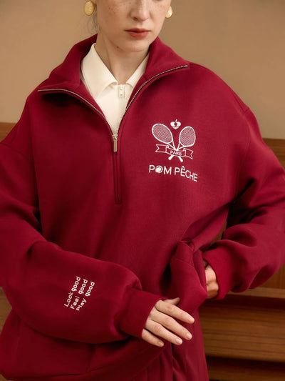 Person wearing a red fleece pullover with 'Pom Peche' branding.