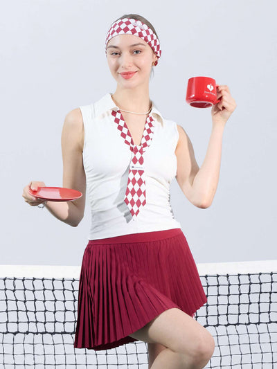 White slim-fit tennis top with a playful red diamond-pattern tie detail, styled for a chic on-court look.