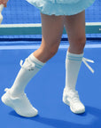 White knee-high tennis socks with sky blue stripes, bow detail, and logo embroidery.