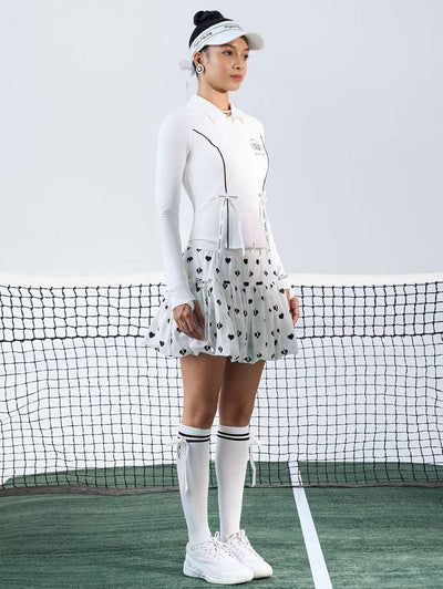 White sun-protective tennis jacket with a sculpted fit, adjustable waist ties, and dual ball pockets.