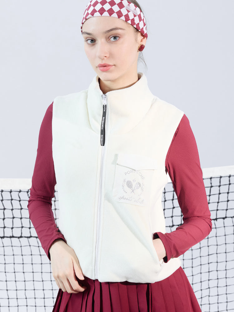 Warm white fleece vest with high-neck zip design and embroidered chest pocket, styled on the tennis court.
