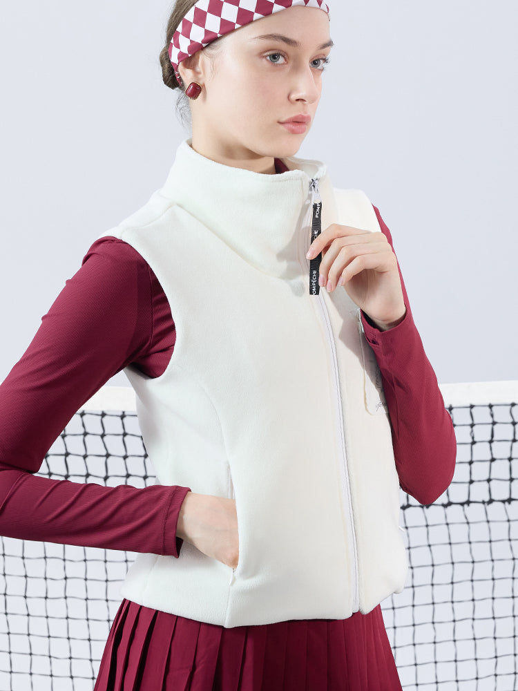 Warm white fleece vest with high-neck zip design and embroidered chest pocket, styled on the tennis court.