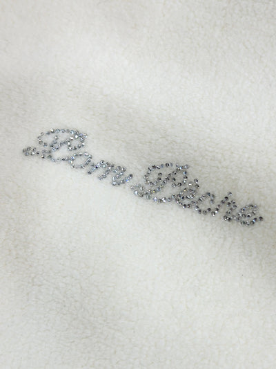 Warm white fleece vest with high-neck zip design and embroidered chest pocket, styled on the tennis court.